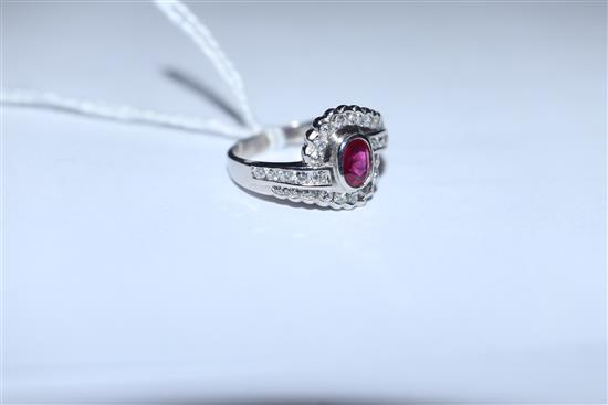 A modern stylish 18ct white gold, ruby and diamond oval cluster ring, with diamond set shoulders, size L/M.